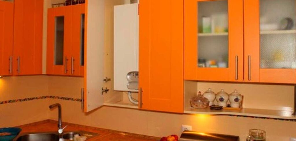 Газовая колонка, спрятанная в навесной кухонный шкаф с вентиляционными отверстиями